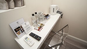 A hotel room's service counter with a menu, a kettle, a toaster, and a remote control. - Mstay Russell Court Hotel (London)