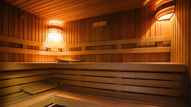 A sauna with wooden benches and a tiled floor. - Hotel Ambassadeur (Ostend)