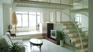 Una sala de estar moderna con chimenea, televisor y escalera.