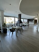 A spacious, modern kitchen with a central island, large windows, and a staircase leading to an upper level.