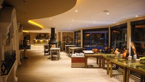 A spacious hotel lobby with a central bar area, seating arrangements, and large windows providing views. - Ata Park Hotel (Fethiye)