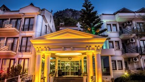 A hotel entrance with a classical facade, columns, and a staircase leading to the entrance. - Ata Park Hotel (Fethiye)