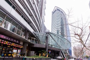 A modern building with a glass facade and a curved structure.