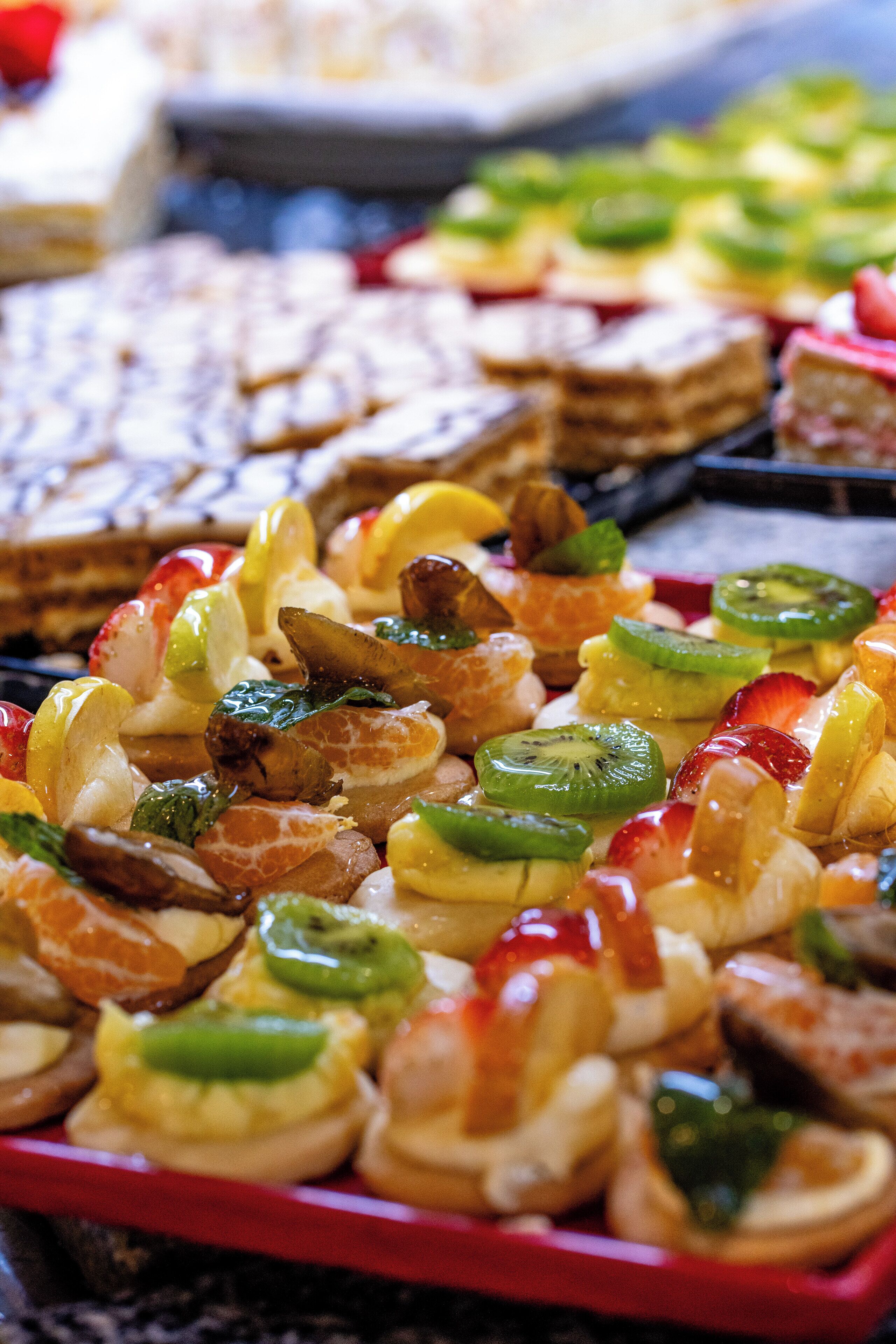 A variety of fruit tarts on a tray.