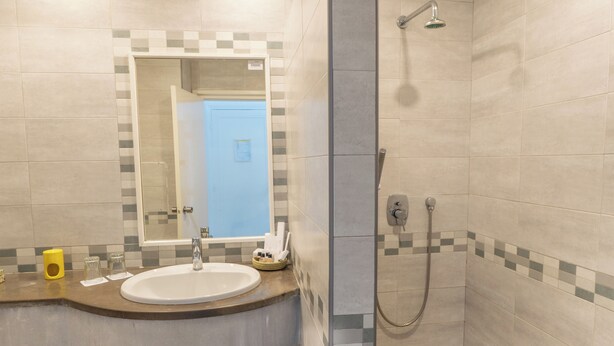 Un baño con lavamanos, espejo y ducha.