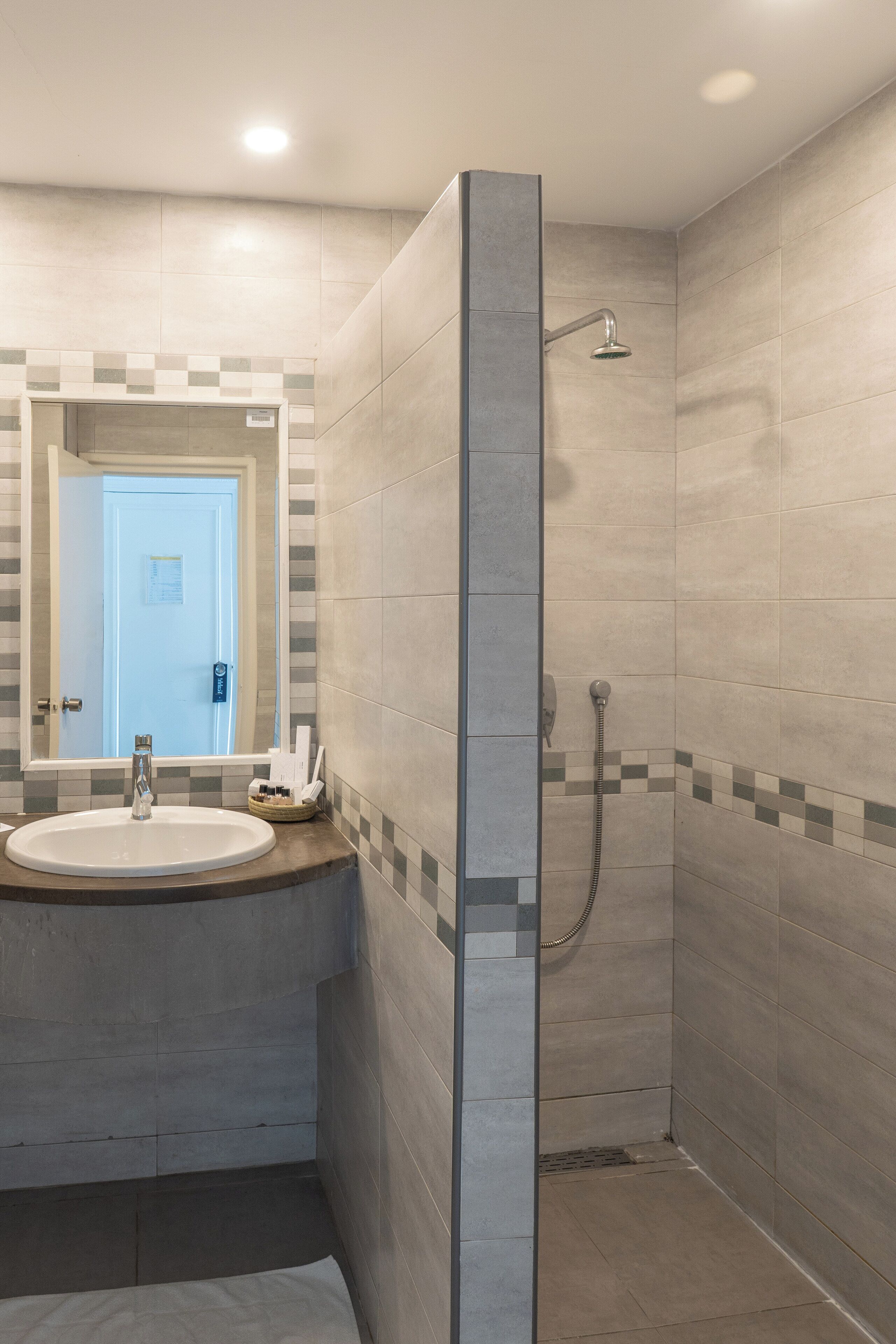 A modern bathroom with a shower, a sink, and a mirror.