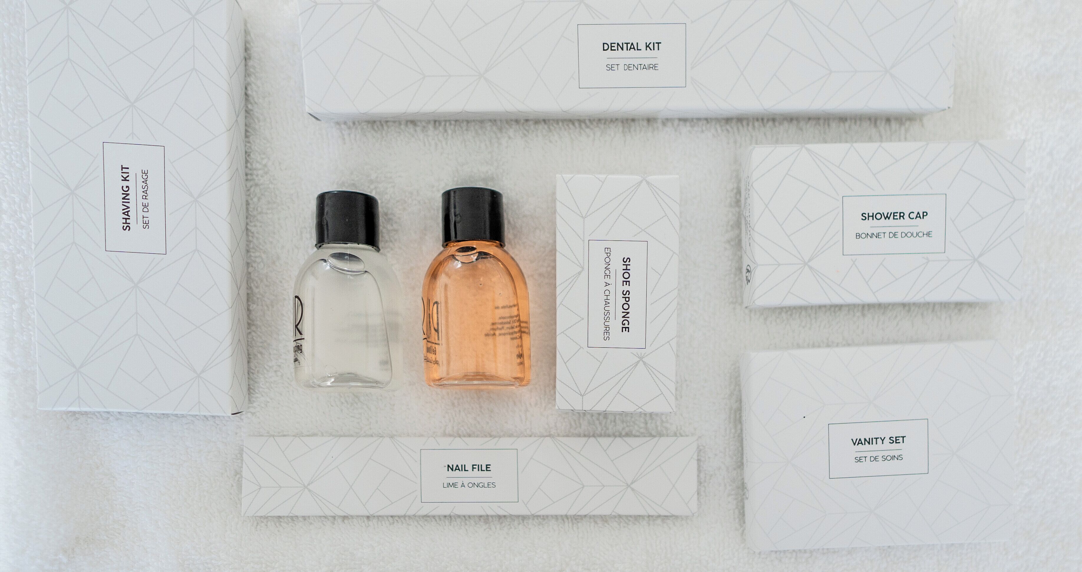 Un ensemble d’articles de toilette soigneusement rangés, comprenant un kit de rasage, une lime à ongles et un bonnet de douche.