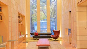 A modern interior with a sofa, a red chair, and a small table. - Hotel Resol Trinity Sapporo (Sapporo)