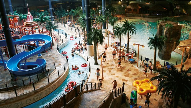 An indoor water park with multiple slides, pools, and inflatable rafts. - Lalandia Resort Billund (Billund)