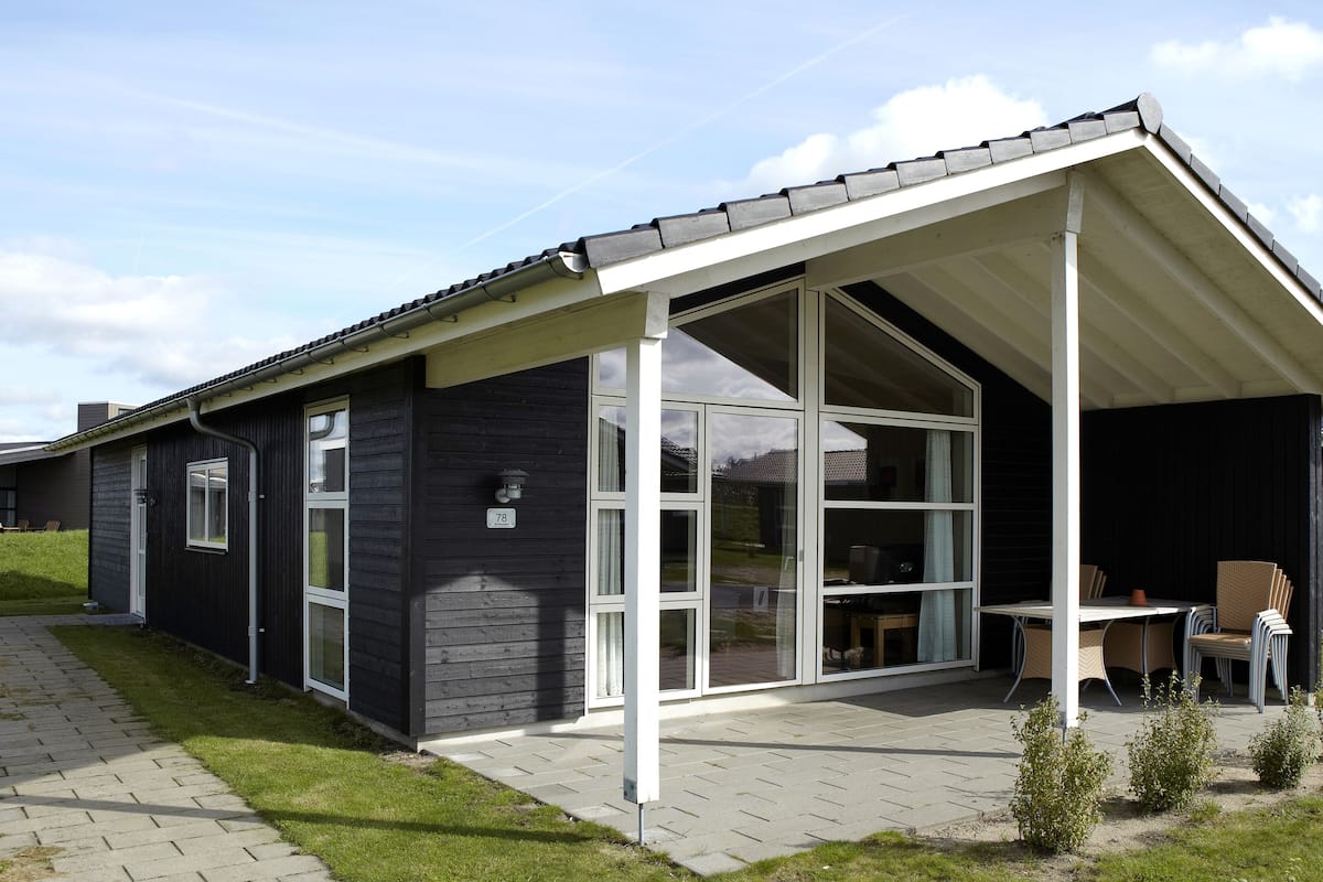 A modern building with large windows and a covered patio area.