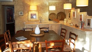 Een eetgedeelte met een houten tafel, stoelen en een buffet.