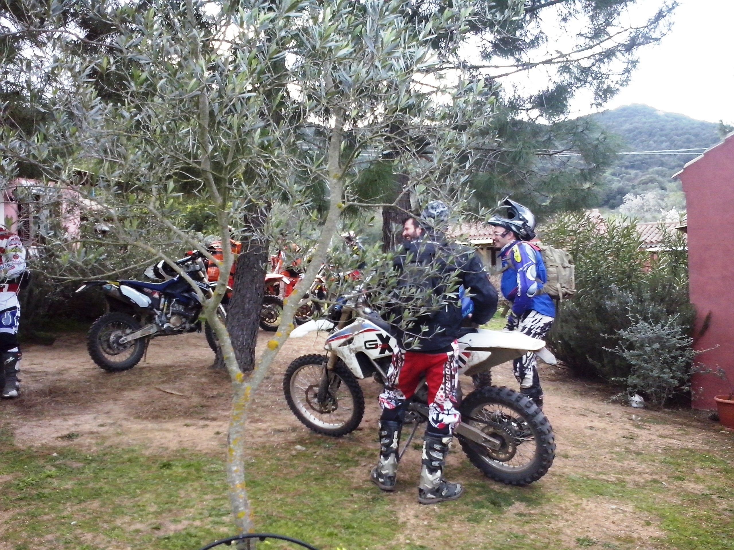 A dirt bike track with multiple riders and their bikes.