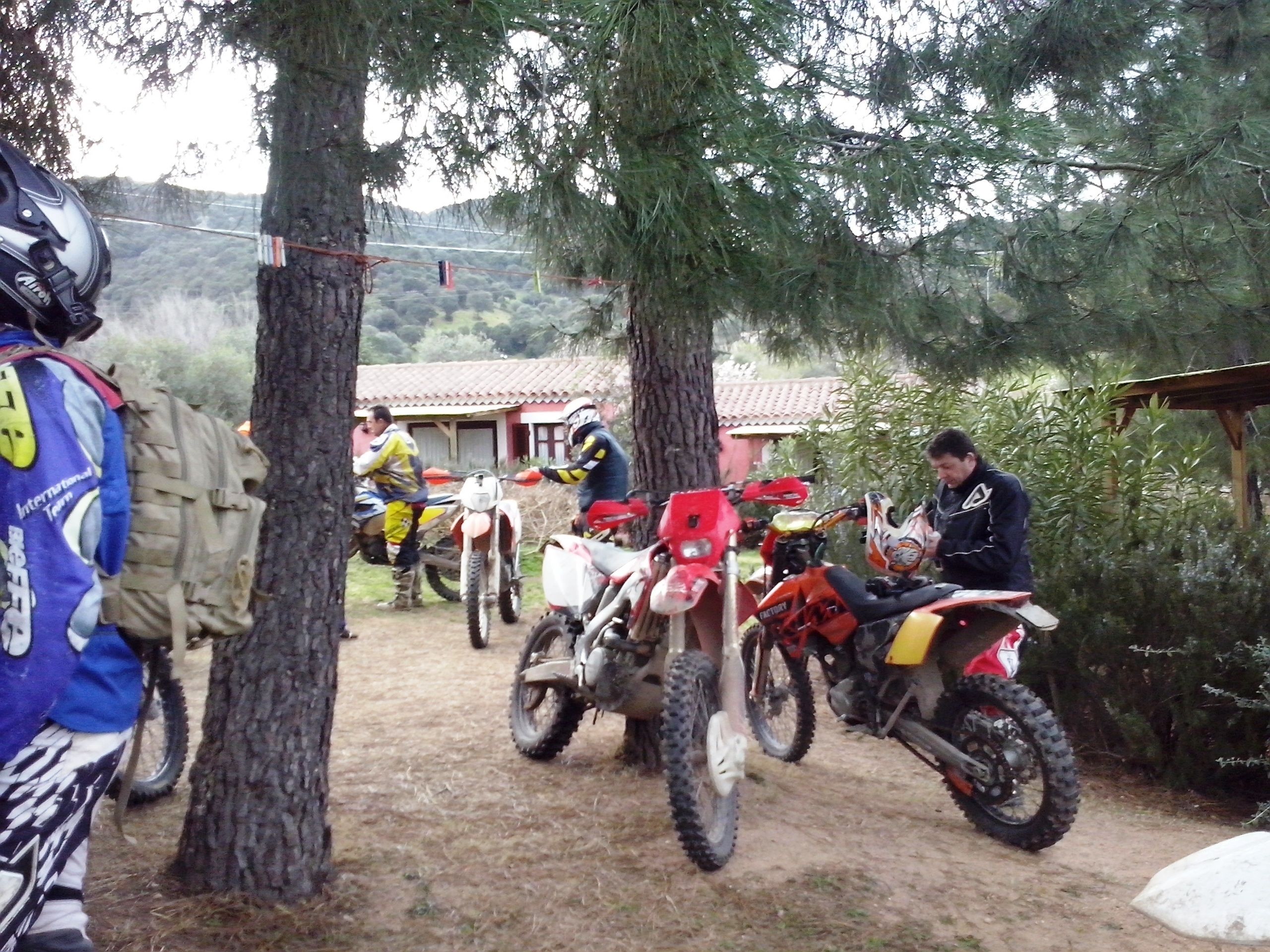 Un sentiero sterrato con diverse moto da cross parcheggiate.