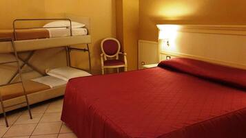 A hotel room with a bunk bed, a single bed, a chair, and a bedside table.