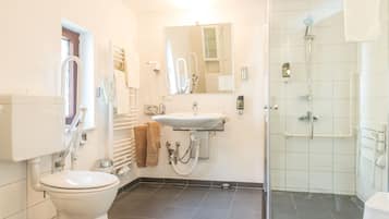 Uma casa de banho moderna com sanita, lavatório e chuveiro.