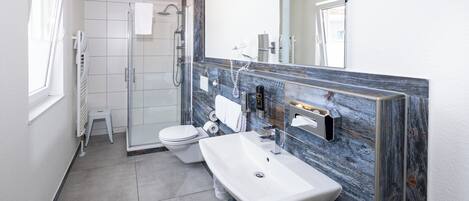 Un baño moderno con ducha, inodoro y lavabo.