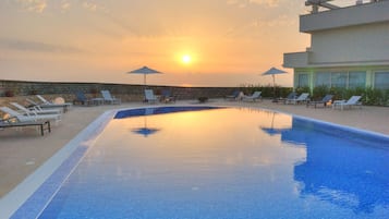 Una piscina al aire libre de temporada, sombrillas