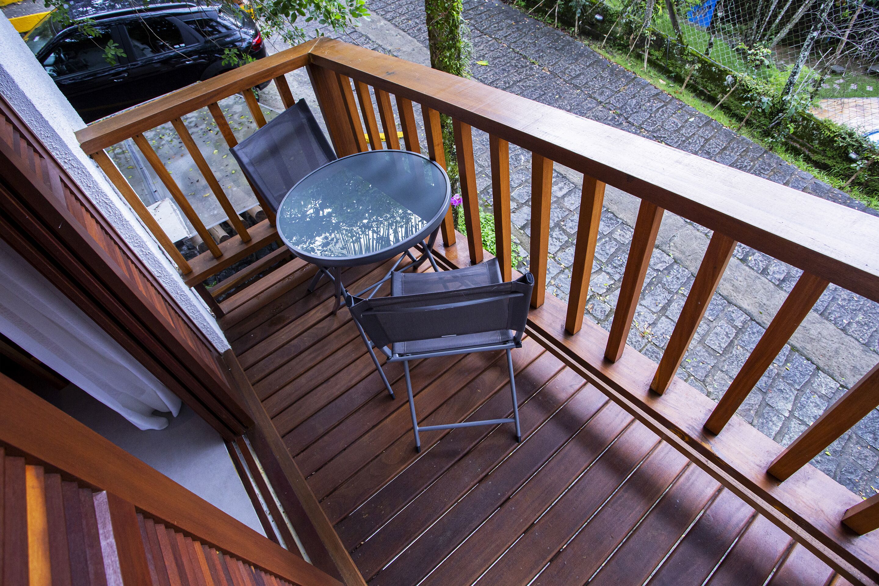 Una terraza de madera con una mesa y dos sillas.