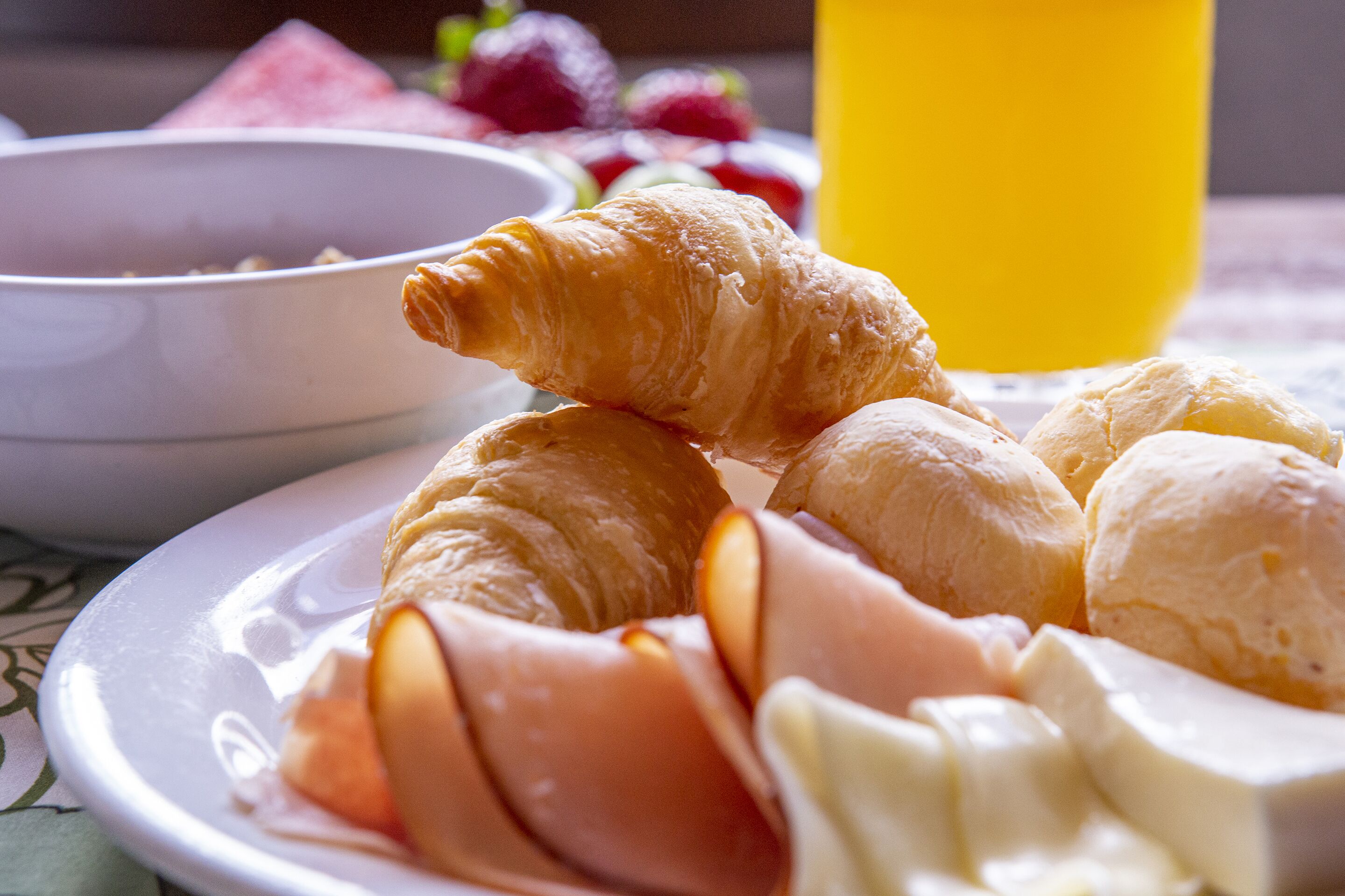 A plate with croissants, cheese, and ham.