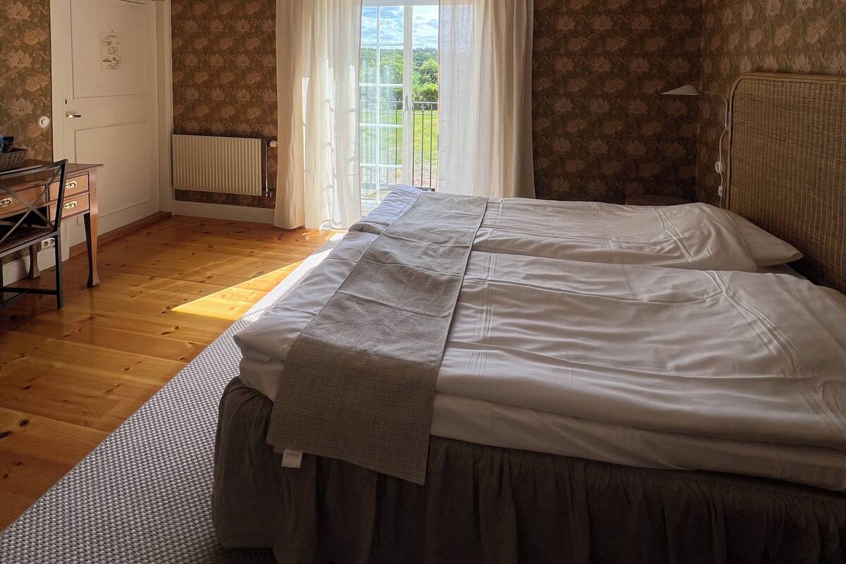 Ein Schlafzimmer mit einem großen Bett, einem Schreibtisch und einer Heizung.