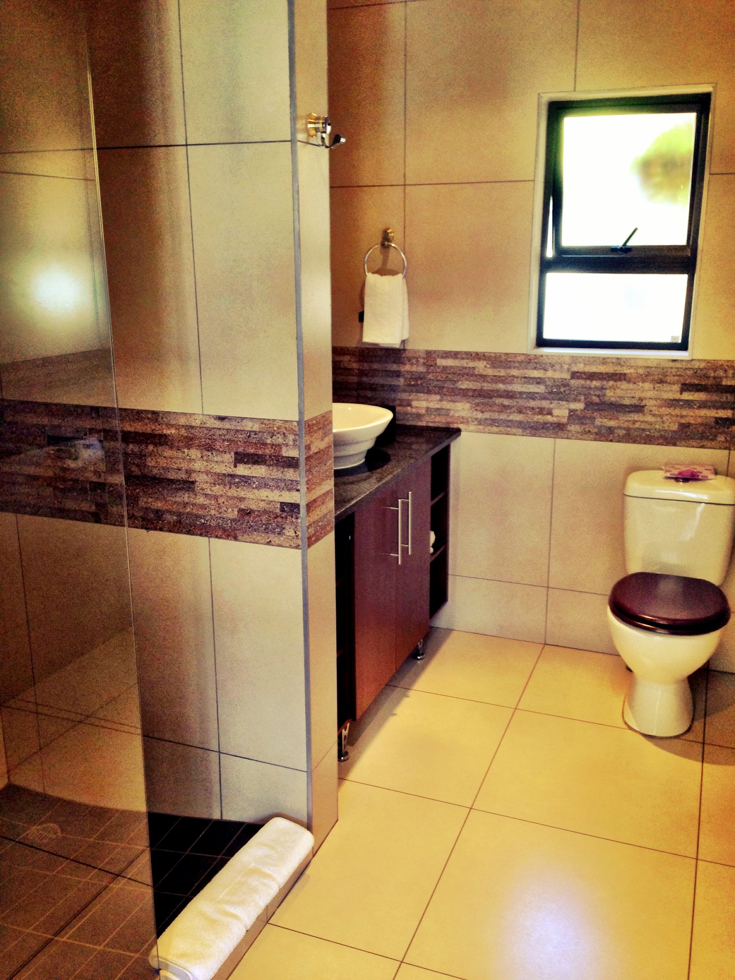 A bathroom with a toilet, sink, and shower area.