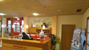 Un mostrador de recepción con detalles de madera, un cartel arriba y una dirección web.