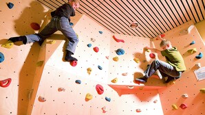 Una pared de escalada con múltiples puntos de agarre y techo de madera.