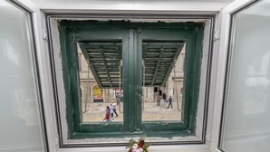 A window with a green frame and a potted plant on the sill. - Studio Apartments Stradun (Dubrovnik)