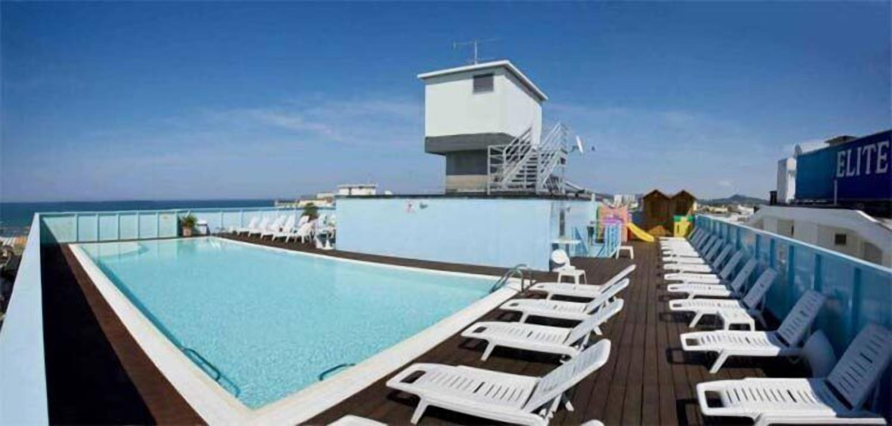 A pool area with lounge chairs and a lifeguard station on a cruise ship deck.