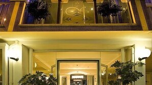Hotellin sisäänkäynti, jossa on kyltti, jossa lukee ”ELITA HOTEL”, ja jonka sisällä näkyy vastaanottotiski.