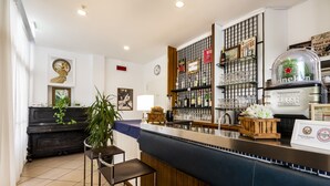 Eine Bar mit Theke, Hockern und einer Auswahl an Flaschen und Gläsern.