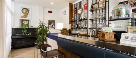 A bar area with a counter, stools, and a display of various bottles and glasses.