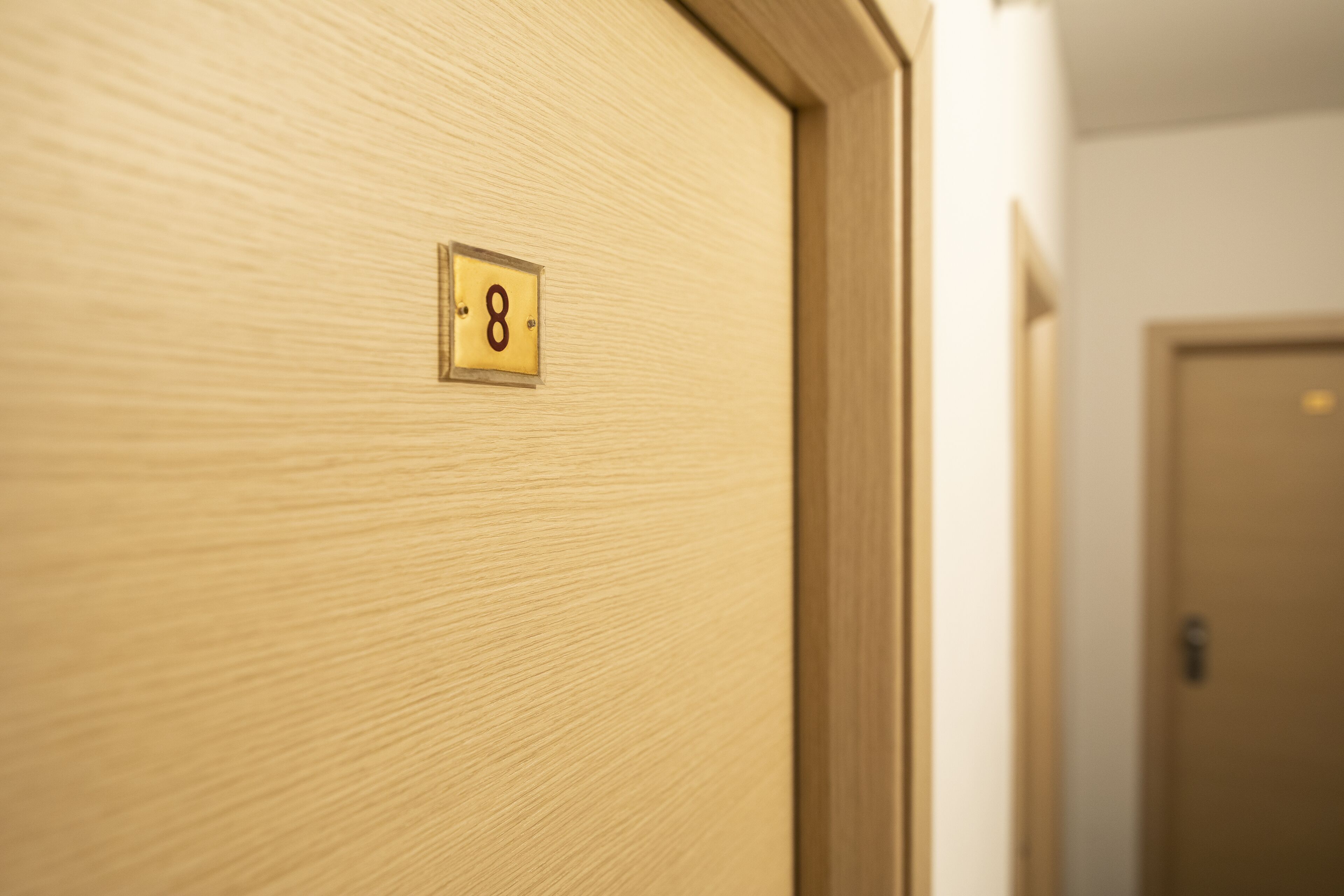 A wooden door with a number plate indicating room number 8.