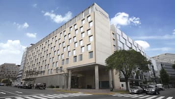 A modern hotel with a flat facade, multiple floors, and a prominent entrance.