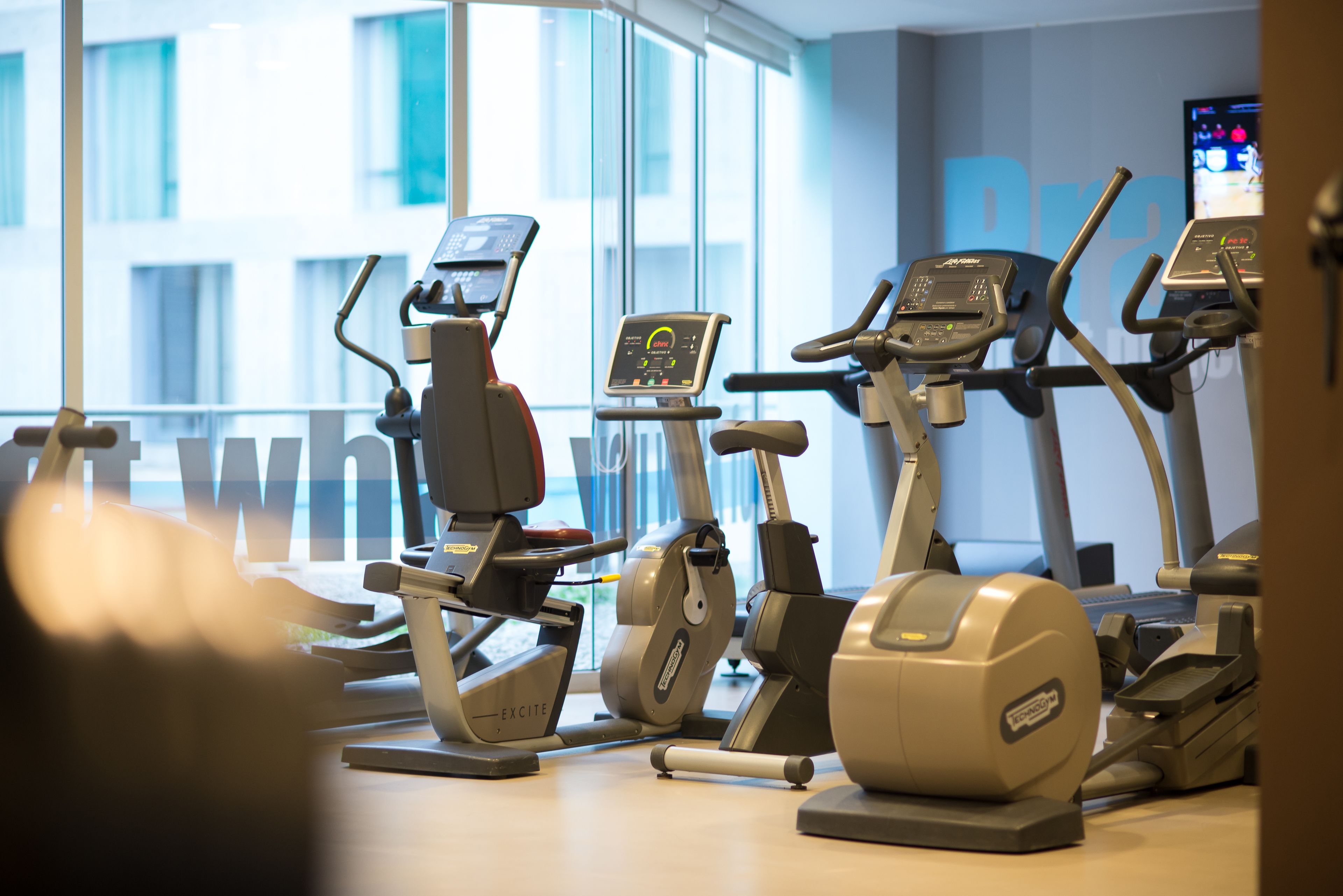 A gym with multiple treadmills, each equipped with digital displays.