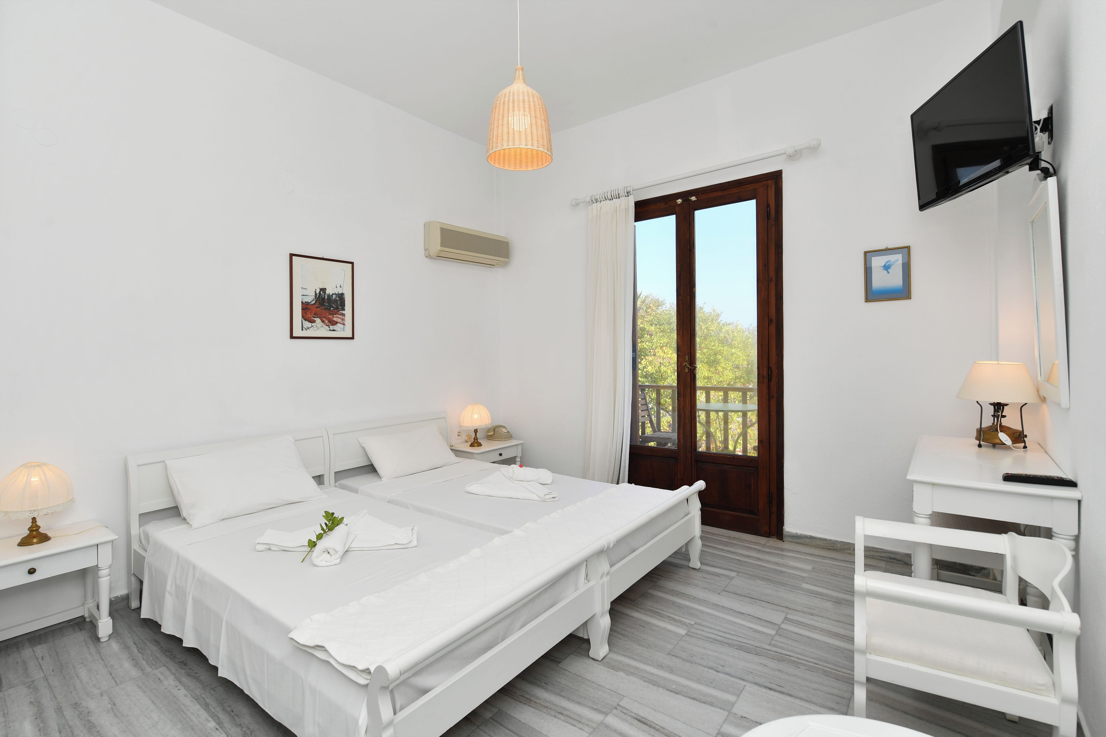 Ein Hotelzimmer mit Bett, Nachttischen, Fernseher und Fenster mit Blick.