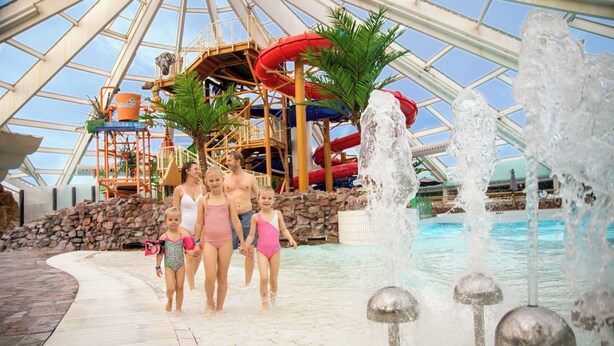 Un parc aquatique doté d’une grande piscine intérieure, de toboggans et d’une aire de jeux.