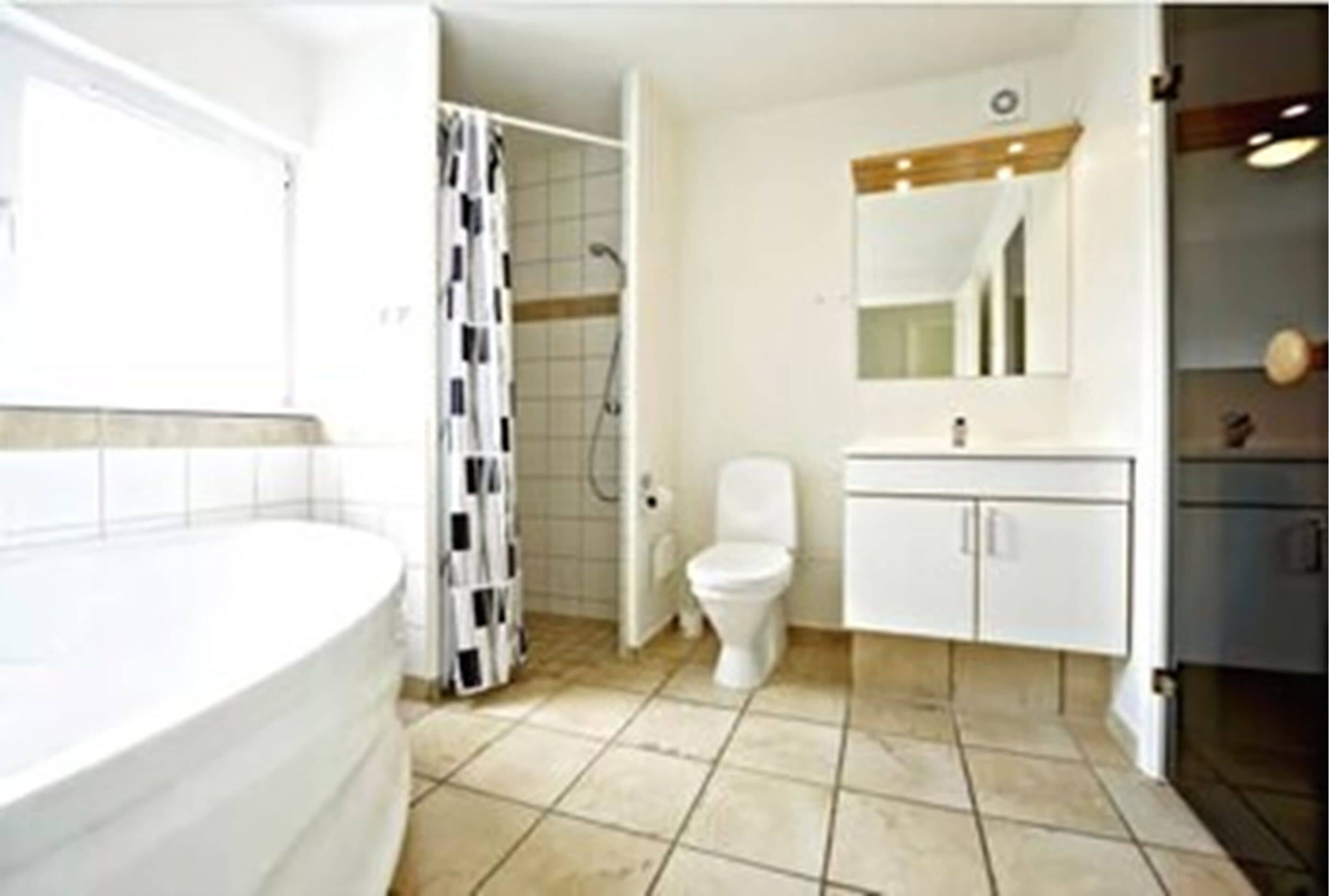Un baño moderno con bañera, inodoro y ducha.