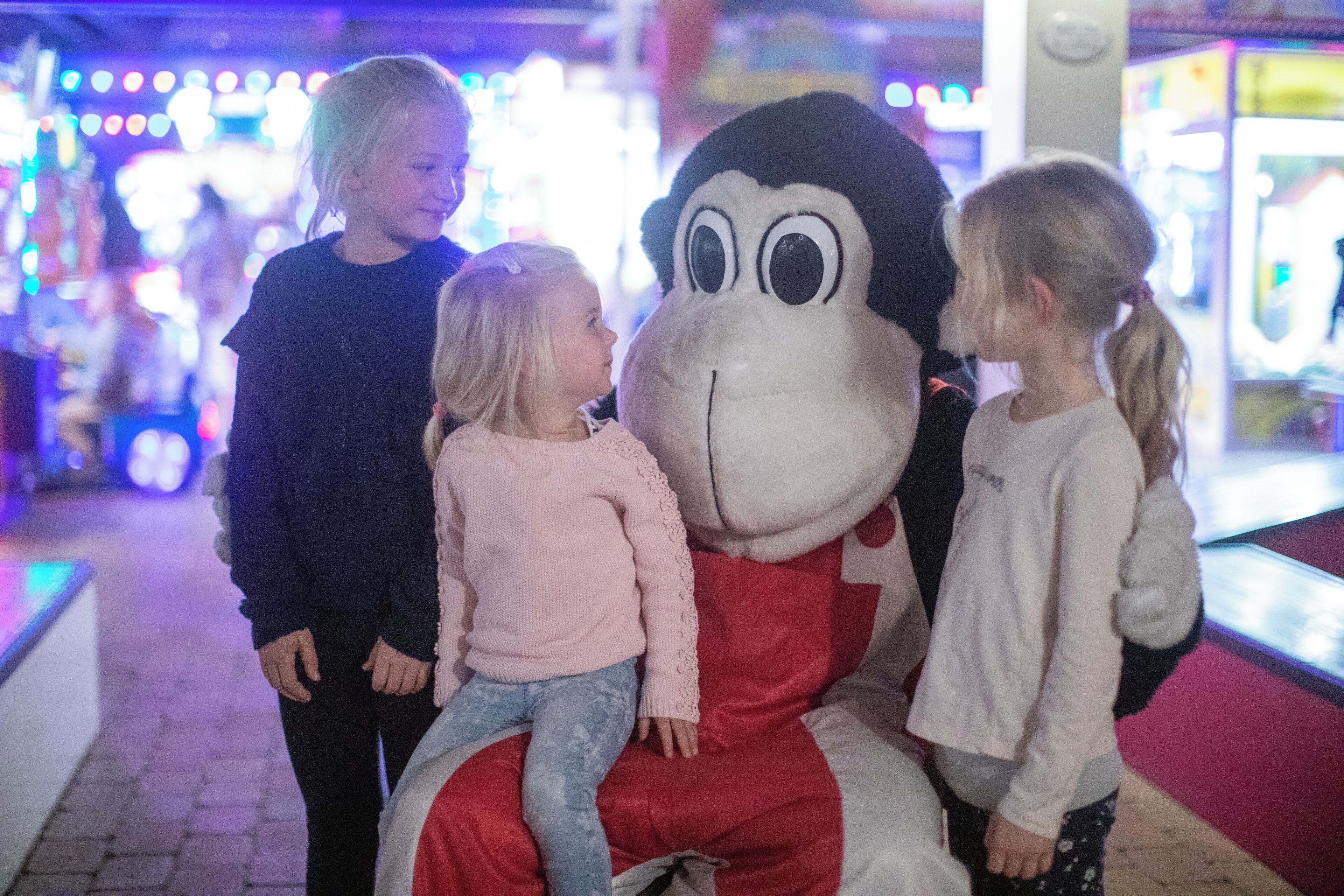 A large plush toy mascot in a brightly lit indoor setting.