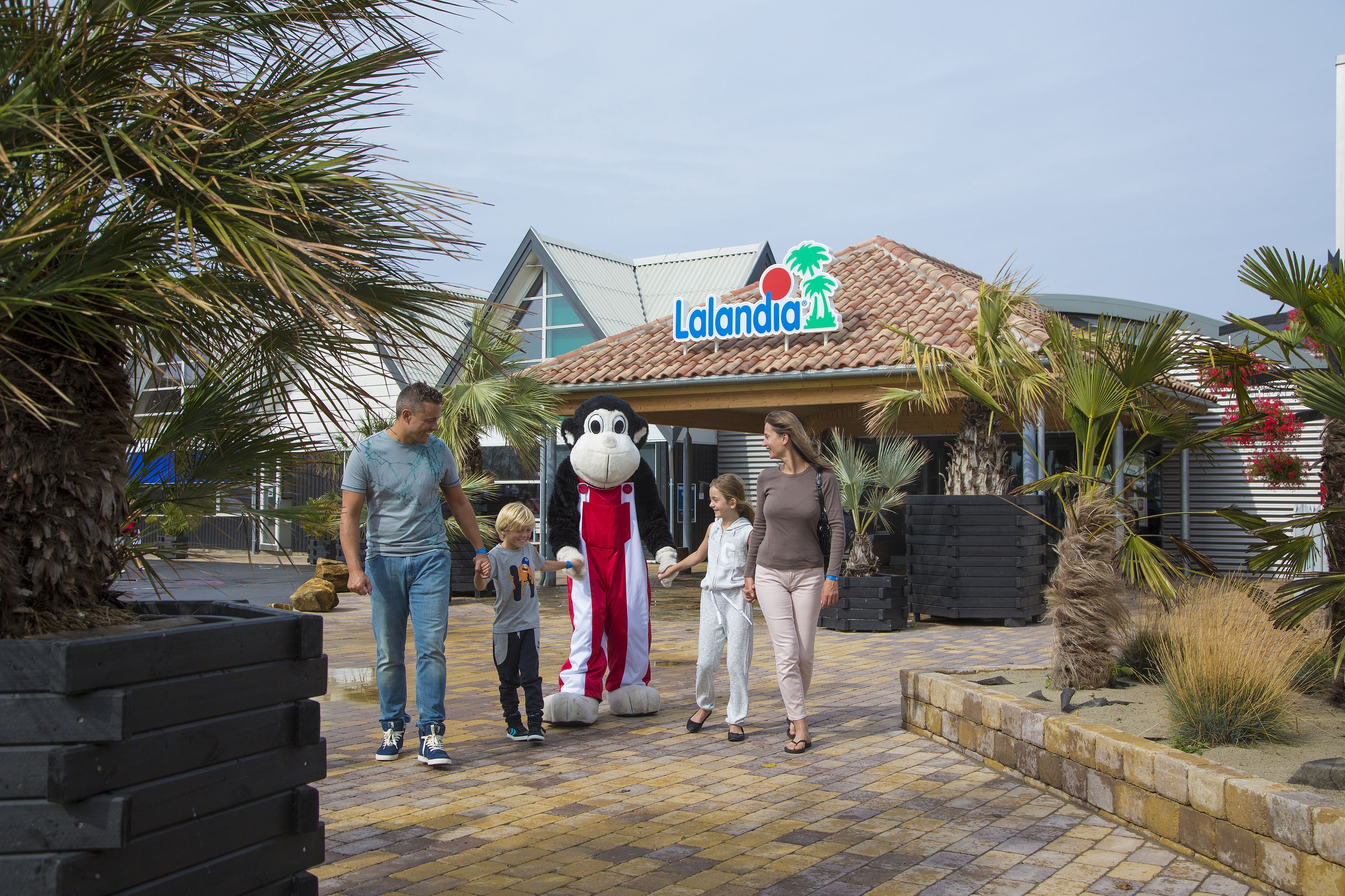 A family walking towards a building with a sign that reads "Lalandia."