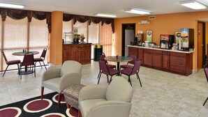 A hotel lobby with a dining area, a kitchen, and a reception desk. - Americas Best Value Inn & Suites Sheridan (Sheridan)