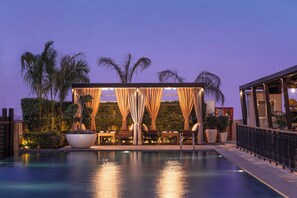 A poolside area with a covered seating area, a large planter, and a view of the pool. - Holiday Inn New Delhi Mayur Vihar Noida by IHG (New Delhi)