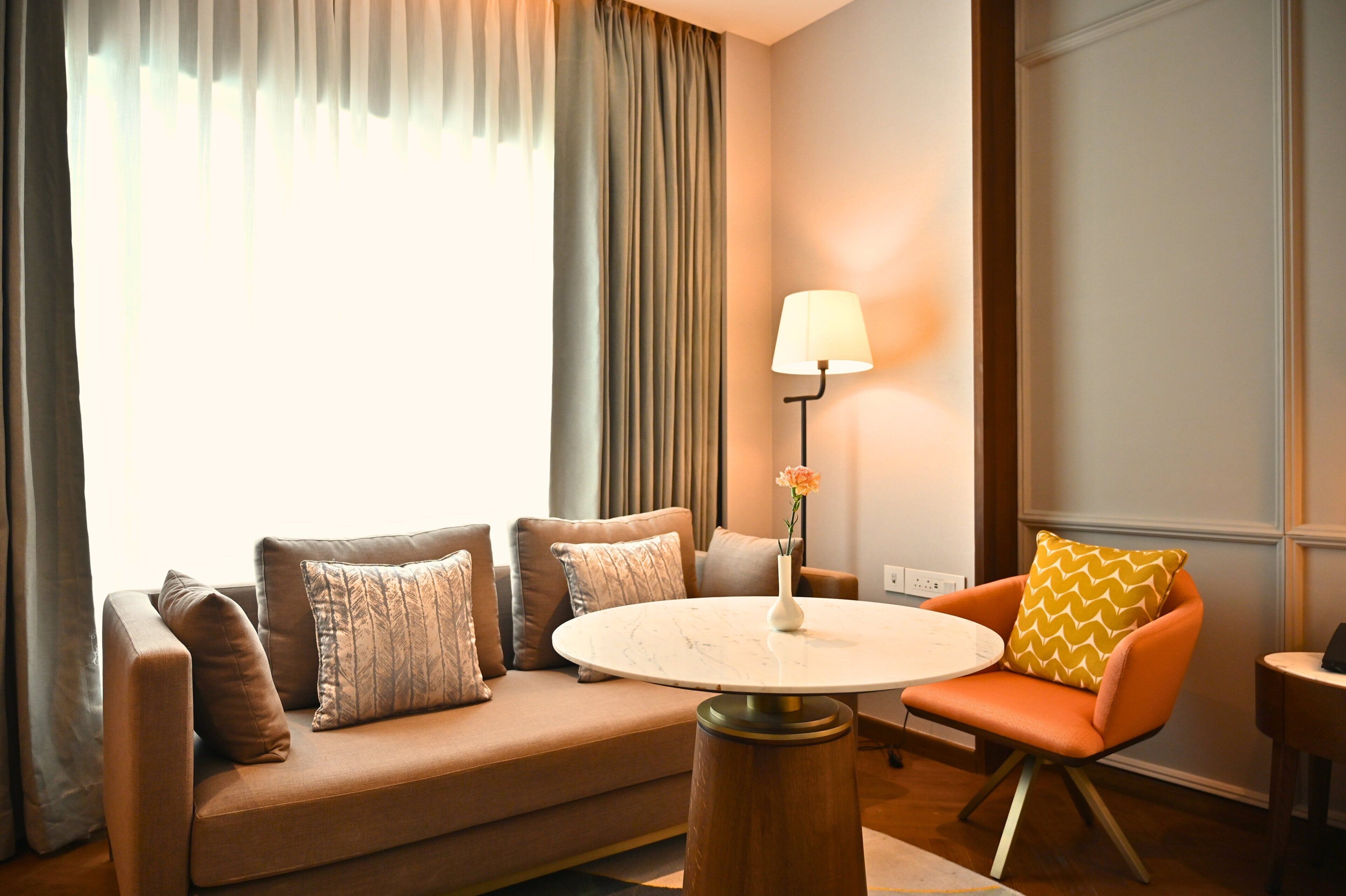 A modern living room with a sofa, armchair, and round coffee table.