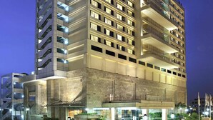 Un hotel moderno a più piani, con un ingresso imponente e un parcheggio sotterraneo.