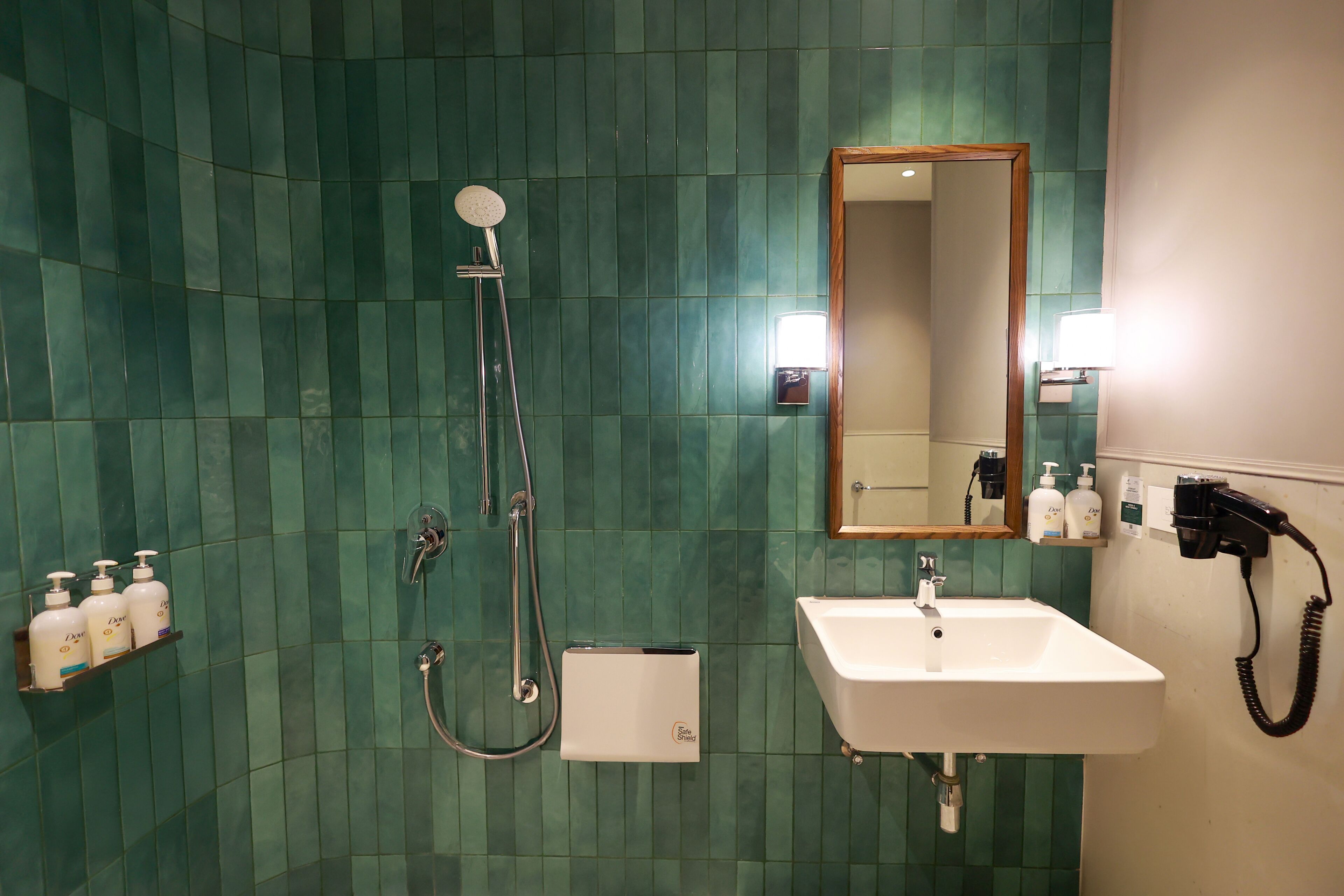 A bathroom with a shower, sink, and mirror.
