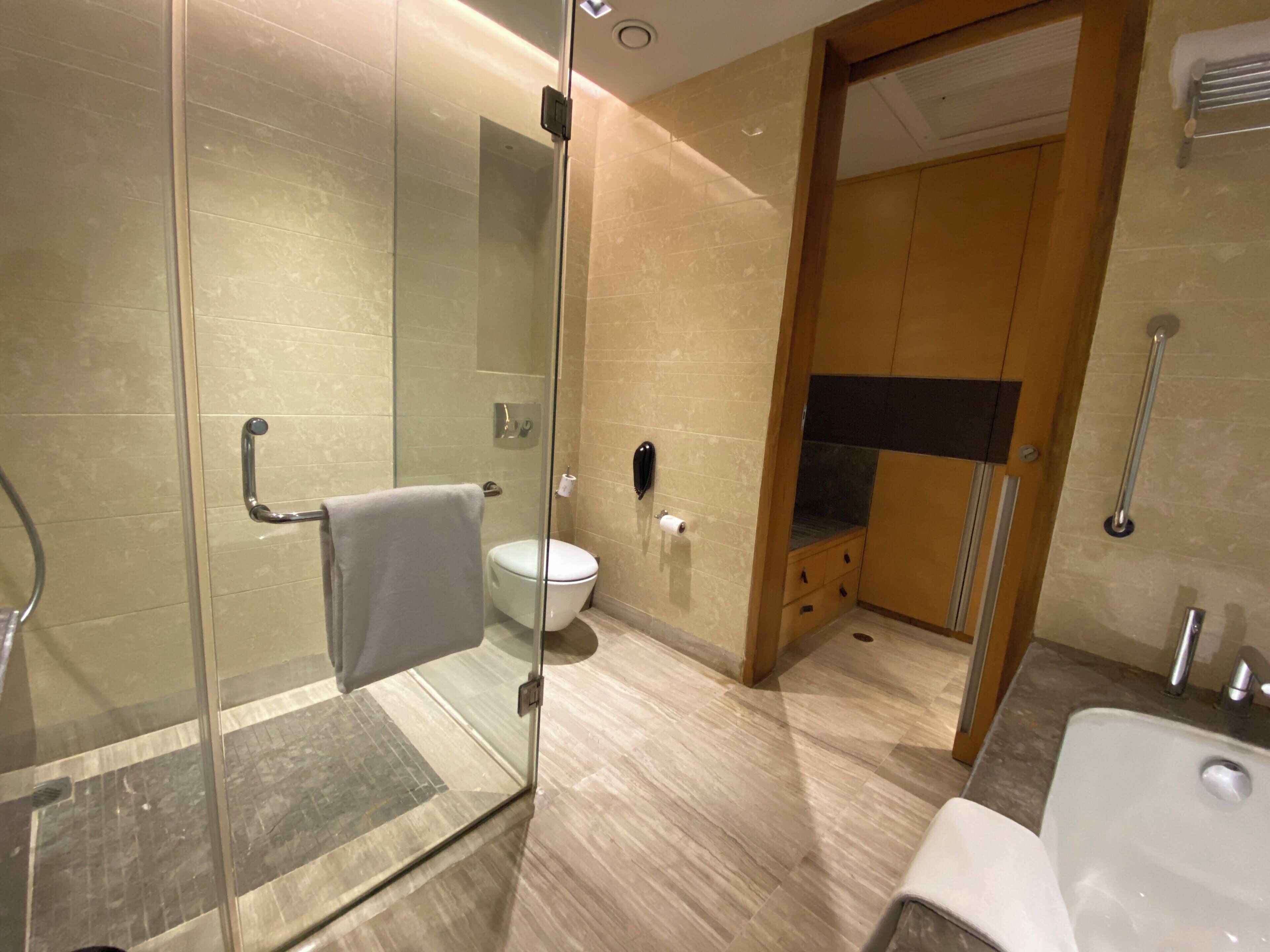 A modern bathroom with a glass shower enclosure, a toilet, and a sink.