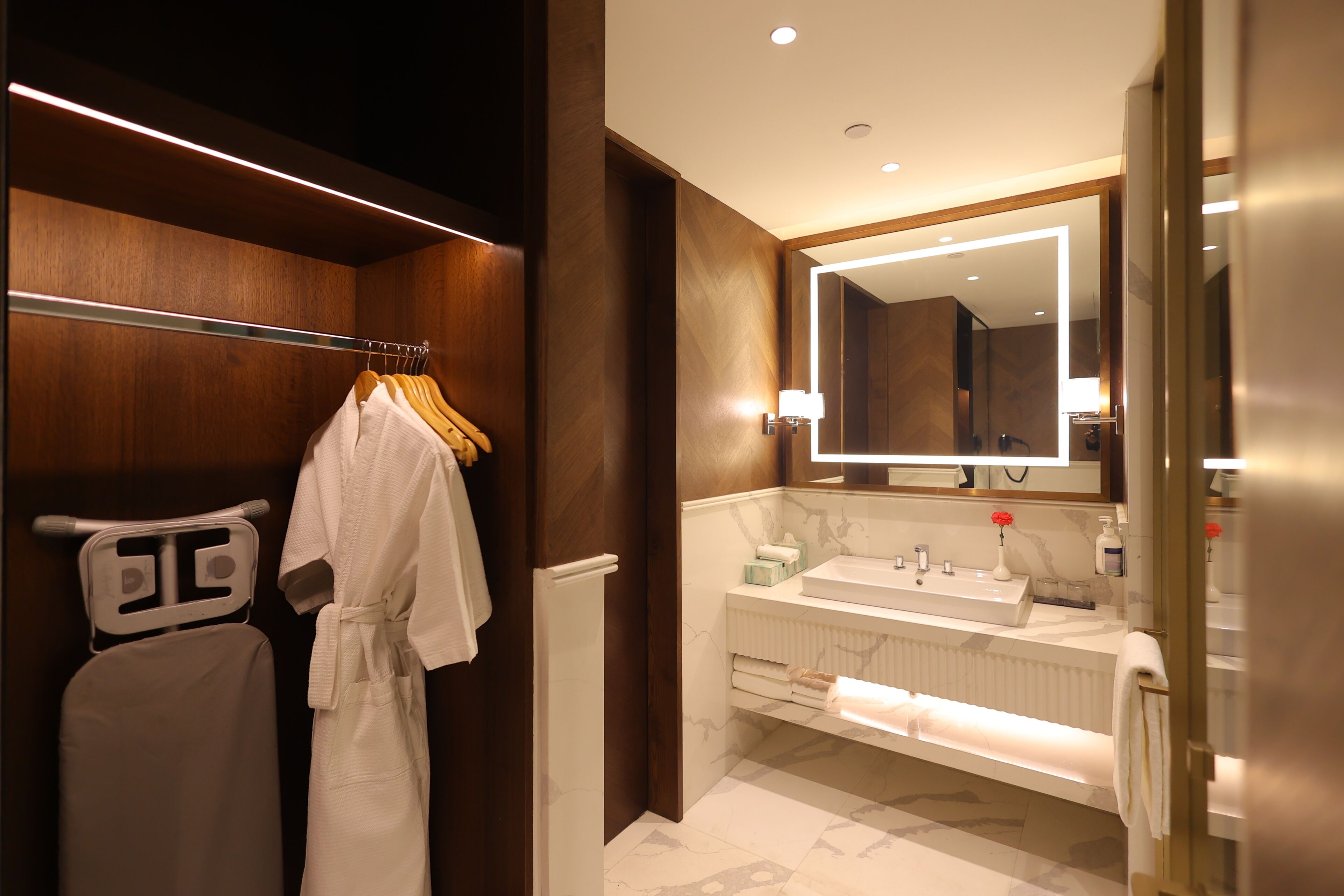 A modern bathroom with a walk-in shower, a large mirror, and a vanity with a double sink.