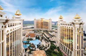 A high-rise hotel with a central courtyard, multiple balconies, and a swimming pool. - Galaxy Hotel (Cotai)
