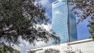A tall, modern building with a glass facade and the name "Westin" on the top.