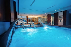 An indoor swimming pool with multiple lanes, a changing room area, and a reception desk.